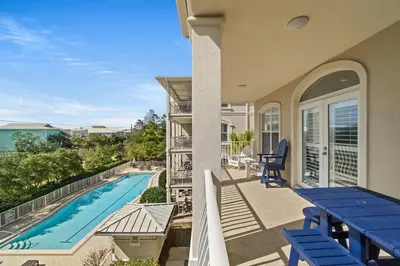 a balcony with blue chairs and a swimming pool at 30A Villas at Seagrove by Panhandle Getaways in Santa Rosa Beach
