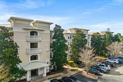 an apartment building with cars parked in a parking lot at 30A Villas at Seagrove by Panhandle Getaways in Santa Rosa Beach
