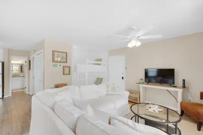 a white living room with a white couch and a tv at Beachwood Villas 1A- Beach Haven in Santa Rosa Beach