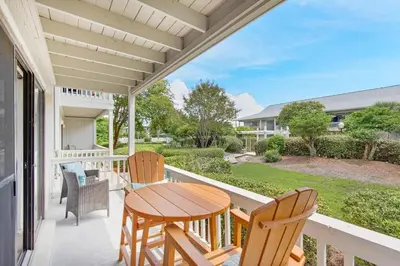 a patio with a table and chairs on a balcony at Beachwood Villas 1A- Beach Haven in Santa Rosa Beach