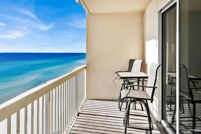 a balcony with chairs and a view of the ocean at Celadon 1103 - Beach Paradise in Panama City Beach