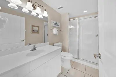 a white bathroom with a shower and a toilet at Celadon 1103 - Beach Paradise in Panama City Beach