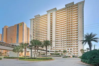 a large building with palm trees in front of it at Celadon 1103 - Beach Paradise in Panama City Beach