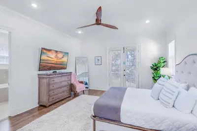 a bedroom with a bed and a dresser and a fan at Seas the Day on 30A in Santa Rosa Beach