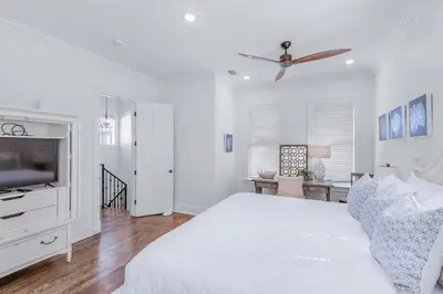 a white bedroom with a bed and a tv at Seas the Day on 30A in Santa Rosa Beach