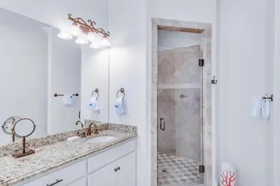 a white bathroom with a shower and a sink at Seas the Day on 30A in Santa Rosa Beach