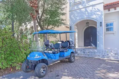 a blue golf cart parked in front of a house at Seas the Day on 30A in Santa Rosa Beach