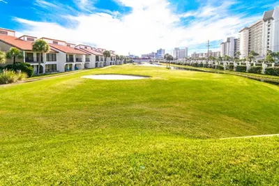 a golf course with a green field and buildings at Edgewater Tower 3-1012 in Panama City Beach