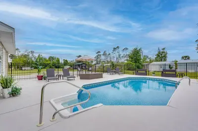 a swimming pool with chairs and a table at Southport Getaway with Private Pool about 15 Mi to PCB! in Southport