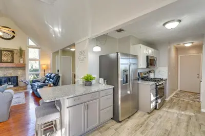 a kitchen with stainless steel appliances and a living room at Southport Getaway with Private Pool about 15 Mi to PCB! in Southport