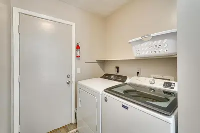 a white washer and dryer in a small kitchen at Southport Getaway with Private Pool about 15 Mi to PCB! in Southport