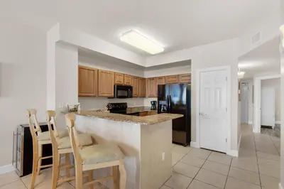 a kitchen with a counter and some chairs in it at Sunrise Beach #903 in Panama City Beach