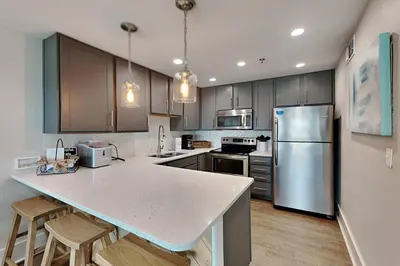 a kitchen with a counter top and a refrigerator at Commodores Retreat #205 in Santa Rosa Beach