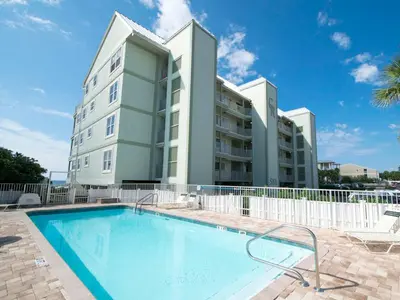 a large building with a swimming pool in front of a building at Commodores Retreat #205 in Santa Rosa Beach