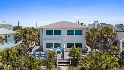 a house on the beach with palm trees at Beach House - Family Tides by Panhandle Getaways in Panama City Beach