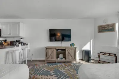 a living room with a flat screen tv on a wall at Top of the Gulf 807 in Panama City Beach