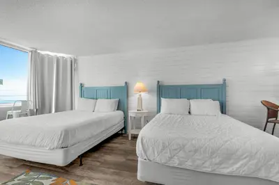 a bedroom with two beds and a window at Top of the Gulf 807 in Panama City Beach