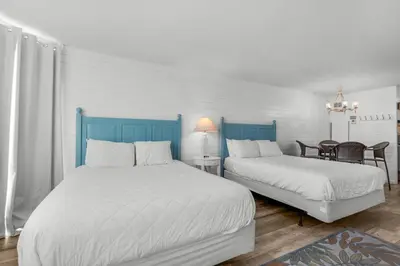 a bedroom with two beds and a table and chairs at Top of the Gulf 807 in Panama City Beach