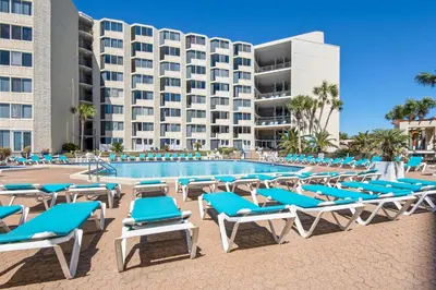 a pool with lounge chairs and a hotel at Top of the Gulf 807 in Panama City Beach