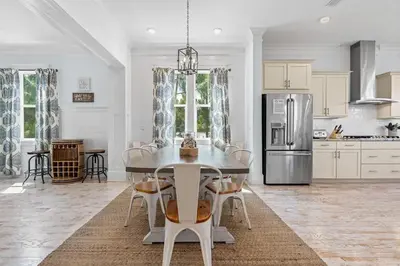 a kitchen with a table with chairs and a refrigerator at Flor Da Li by the Sea in Inlet Beach