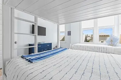 a white bedroom with two beds and a window at Flor Da Li by the Sea in Inlet Beach