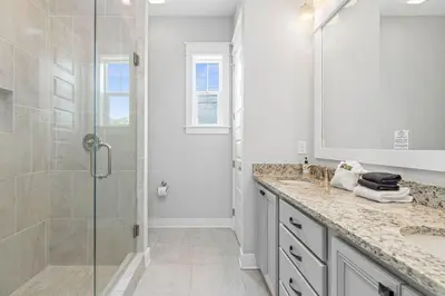 a white bathroom with a shower and a sink at Prominence 30A - Lucky Old Sun in Panama City Beach