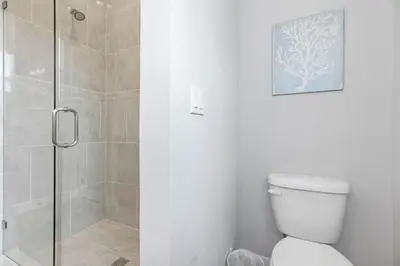 a bathroom with a shower stall and a toilet at Prominence 30A - Lucky Old Sun in Panama City Beach