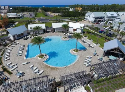an overhead view of a pool with chairs and palm trees at Prominece 30A - Beach Retreat in Santa Rosa Beach