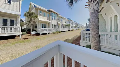 a row of houses on a street with a white railing at Prominece 30A - Beach Retreat in Santa Rosa Beach