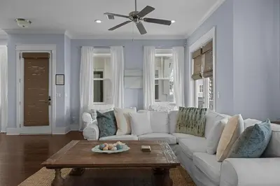 a living room with a white couch and a ceiling fan at Prominence 30A - Coastal Cottage in Panama City Beach