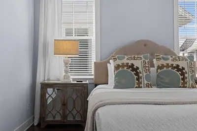 a bedroom with a bed and a lamp on a night stand at Prominence 30A - Coastal Cottage in Panama City Beach