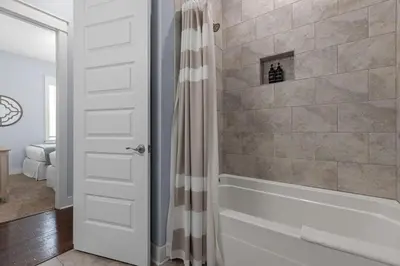 a bathroom with a tub and a shower curtain at Prominence 30A - Coastal Cottage in Panama City Beach