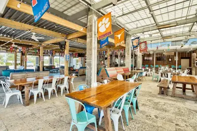 an empty restaurant with wooden tables and chairs at Prominence 30A - Holiday House in Watersound Beach