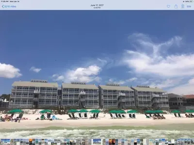 a hotel on a beach with green umbrellas at Beach Happy - Gulf Front in Santa Rosa Beach