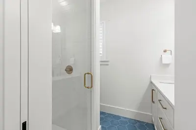 a bathroom with a shower with a blue tile floor at 26 Blue Coast Ct in Inlet Beach