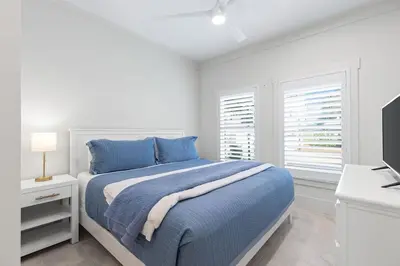 a white bedroom with a bed and a television at 26 Blue Coast Ct in Inlet Beach