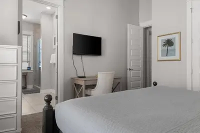 a bedroom with a bed and a desk with a television at Sea Haven At Prominence in Watersound Beach