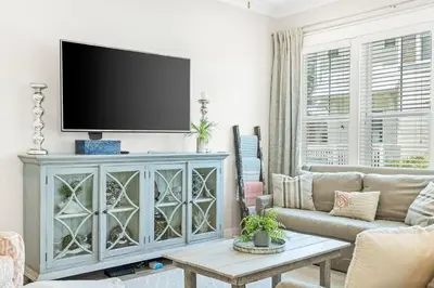 a living room with a tv on top of a cabinet at Prominence 30A - TipSea Kitty in Santa Rosa Beach