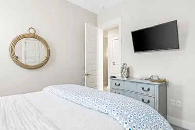 a bedroom with a bed and a flat screen tv at Prominence 30A - TipSea Kitty in Santa Rosa Beach