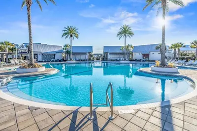 a large swimming pool with palm trees in a resort at Prominence 30A - TipSea Kitty in Santa Rosa Beach
