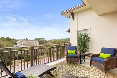 a patio with two chairs and a table on a balcony at Paradise Found on 30A in Santa Rosa Beach