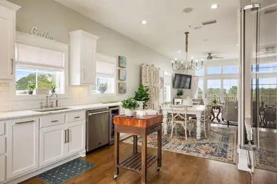 a kitchen with white cabinets and a dining room at Paradise Found on 30A in Santa Rosa Beach