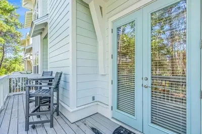 a porch with two chairs and a door at Seas The Day 30A in Santa Rosa Beach
