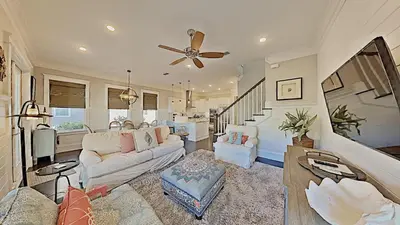 a living room with a couch and a ceiling fan at Prominence Southside - Blue Skies in Watersound Beach