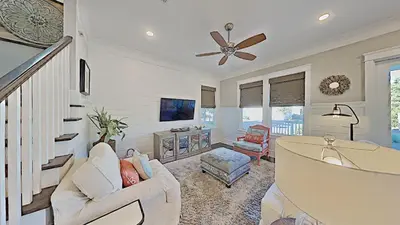 a living room with white furniture and a ceiling fan at Prominence Southside - Blue Skies in Watersound Beach
