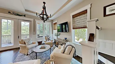 a living room with couches and a chandelier at Pines and Palmettos in Santa Rosa Beach