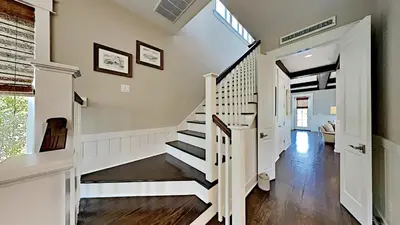 a staircase in a home with white walls and wood floors at Pines and Palmettos in Santa Rosa Beach