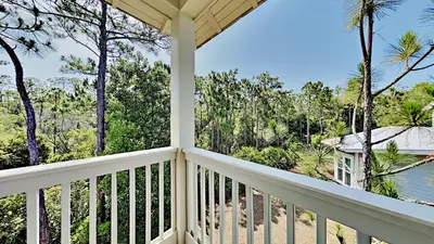 a porch with a view of the beach and trees at Pines and Palmettos in Santa Rosa Beach