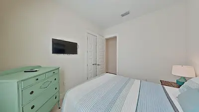 a bedroom with a bed and a dresser and a tv at Prominence 30A - Mint Julep in Inlet Beach