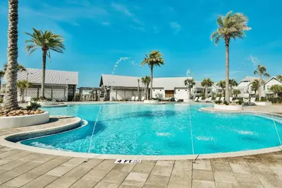 a swimming pool with palm trees in a resort at Prominence 30A - Mint Julep in Inlet Beach